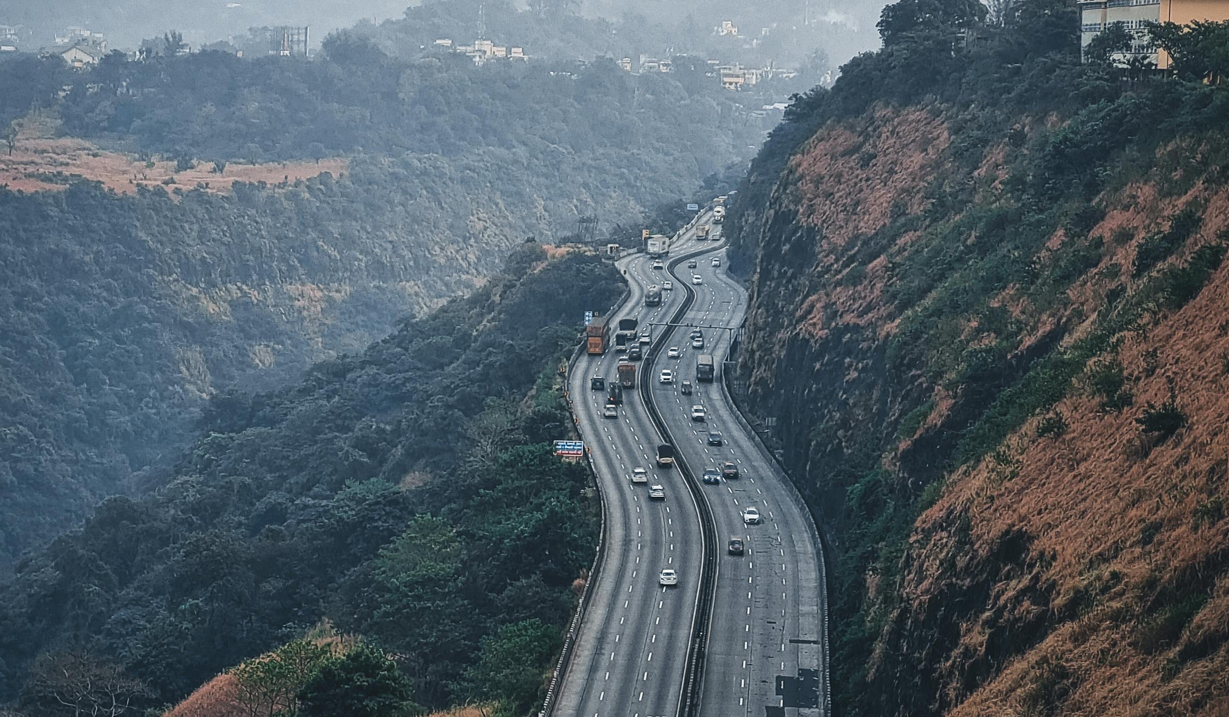 Mumbai–Pune Expressway winding through the Lonavala ghats, hazy hills on either side